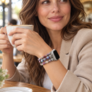 CosmicBloom — pulseira com relógio num pulso de mulher, num café. Imagem ilustrativa gerada por IA; relógio não incluído.