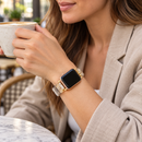 DuneLustre — pulseira com relógio usada por uma mulher, num café. Imagem ilustrativa gerada por IA; relógio não incluído.