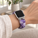VioletHour — pulseira com relógio num pulso de mulher, luz natural. Imagem ilustrativa gerada por IA; relógio não incluído.